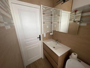 ein Bad mit einem WC, einem Waschbecken und einer Tür in der Unterkunft En face du Stade de France in Saint-Denis