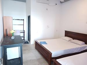 ein Schlafzimmer mit 2 Betten und einem Tisch in einem Zimmer in der Unterkunft SEASHORE Resort & Villa in Talpe