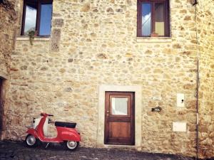 a red motorcycle parked in front of a brick building at Le Pagliare Del Gran Sasso in Assergi