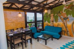 a dining room with a table and blue chairs at Mahi Beach Hotel & Restaurant 