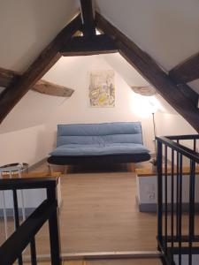 Cette chambre mansardée comprend un lit bleu. dans l'établissement le gîte le CAMÉLIA, à Saint-Aignan