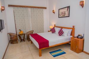 a bedroom with a bed and a table with a telephone at Mahi Beach Hotel & Restaurant 