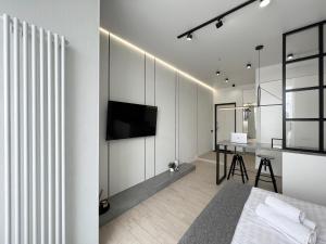 a bedroom with a bed and a desk with a television at Квартира Smart в новом доме in Pavlodar