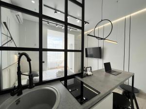 baño con lavabo y escritorio con ordenador portátil en Квартира Smart в новом доме, en Pavlodar