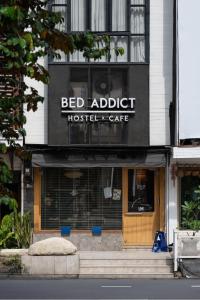 un edificio con una cama adelaide hostel y cafetería en Bed Addict Hostel en Chiang Mai
