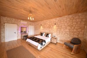 a bedroom with a bed and a stone wall at KYANEAİ VİLLA in Demre