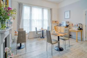 a kitchen and dining room with two tables and chairs at The Mariners - Torquay in Torquay