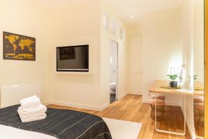 ein Zimmer mit einem Bett, einem Schreibtisch und einem Fernseher in der Unterkunft Le Crébillon - Splendide appartement de 204m2 in Nantes