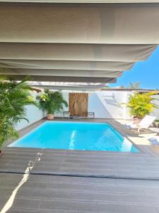 una piscina sotto un edificio con un grande ombrellone di Nosotros Luxury Villa a Los Cristianos