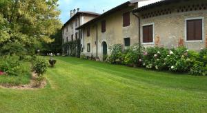 ein altes Gebäude mit einem Hof mit Blumen davor in der Unterkunft Casa Filaferro in Palazzolo dello Stella