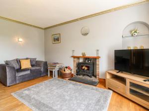 a living room with a couch and a fireplace at Rowan Cottage in Arbroath