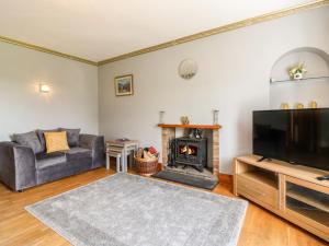 ein Wohnzimmer mit Couch und Kamin in der Unterkunft Rowan Cottage in Arbroath