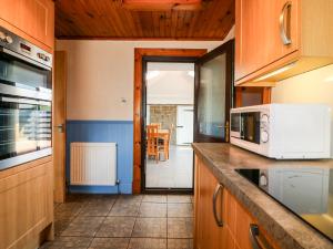 a kitchen with wooden cabinets and a counter top at Rowan Cottage in Arbroath