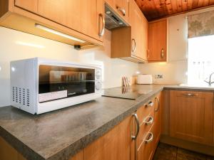 eine Küche mit einer Mikrowelle auf einer Theke in der Unterkunft Rowan Cottage in Arbroath + 20 Fotos