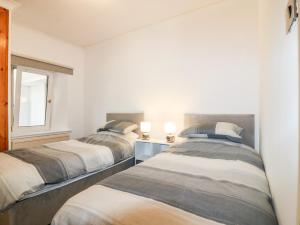 zwei Betten in einem Zimmer mit zwei Lampen und einem Fenster in der Unterkunft Rowan Cottage in Arbroath