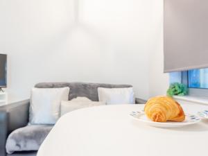 a loaf of bread on a white plate on a bed at Pass the Keys City Centre Haven in Leeds