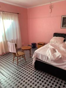 a bedroom with a bed and a chair and a table at A house , Akan trust in Cape Town