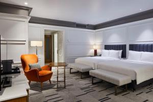 ein Hotelzimmer mit einem großen Bett und einem Stuhl in der Unterkunft London Marriott Hotel County Hall in London