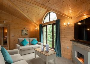 Raywell Hall Country Lodges في Skidby: غرفة معيشة مع أريكة ومدفأة
