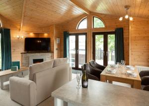 a living room with a table and a fireplace at Raywell Hall Country Lodges in Skidby