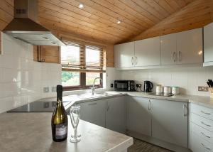 a kitchen with a bottle of wine on a counter at Raywell Hall Country Lodges in Skidby