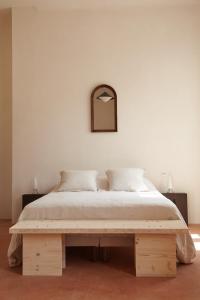 ein Schlafzimmer mit einem großen Bett und einer Holzbank in der Unterkunft CHB - Château de la Haute Borde in Rilly-sur-Loire