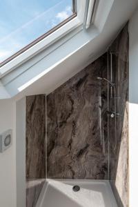a bathroom with a shower with a stone wall at Redland Green Apartments by MyCityHaven in Bristol