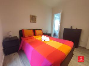 a bedroom with a colorful bed with two white bows at Casas da Biquinha in Sintra