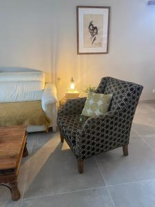 - une chambre avec un lit et une chaise avec un oreiller dans l'établissement Casa unifamiliar FIBES, à Séville