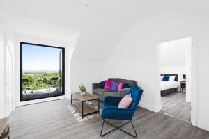 a living room with a blue chair and a couch at Redland Green Apartments by MyCityHaven in Bristol