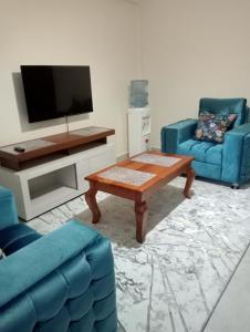- un salon avec deux chaises bleues et une table basse dans l'établissement Amalya suites by TJ, à Eldoret