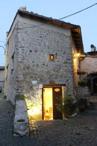 - un bâtiment en pierre avec une porte dans une rue dans l'établissement Le Pagliare Del Gran Sasso, à Assergi