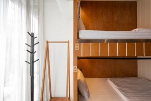 チェンマイにあるBed Addict Hostelのベッドルーム1室(二段ベッド2台、窓付)が備わります。