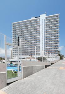 a large tall building with a pool in front of it at Hotel Poseidon Playa in Benidorm