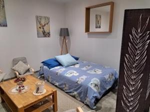 a small bedroom with a bed and a table at Gîte Le piège à rêves in Pierre