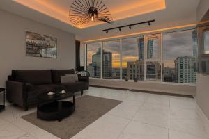 a living room with a couch and a large window at Luxurious Unique Tower Apartment with City Skyline by Renters Prestige in Warsaw