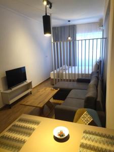 a living room with a couch and a television at Downtown Seaside Studios in Thessaloniki