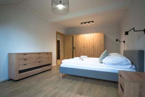 a bedroom with a bed and a wooden dresser at Apartament Pod Reglami in Szklarska Poręba