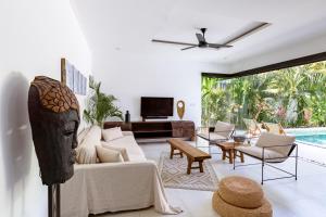 a living room with a couch and a tv at Villa Plumeria - Walk to Bingin Beach in Uluwatu