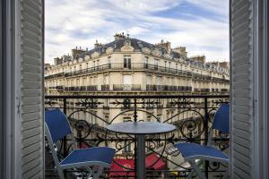 a balcony with a table and chairs in front of a building at Vestay George V in Paris