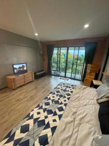 a bedroom with a large bed and a flat screen tv at 420 Canopy Studio Meals Included in Chiang Mai