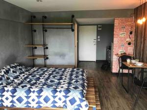 a bedroom with a bed and a table and a brick wall at 420 Canopy Studio Meals Included in Chiang Mai