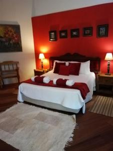 een slaapkamer met een groot bed met een rode muur bij THE ORCHID GUESTHOUSE 
