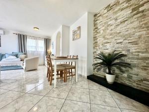 a living room with a table and a brick wall at Vista Bonita, Golf del Sur in San Miguel de Abona