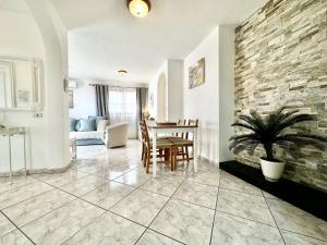 a living room with a table and a stone wall at Vista Bonita, Golf del Sur in San Miguel de Abona