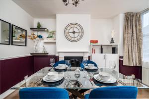 ein Esszimmer mit einem Glastisch und blauen Stühlen in der Unterkunft Watford Casa - 2 bed and 2 bath home near Watford Junction Station in Watford