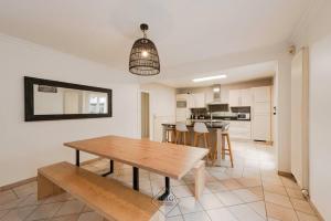 a dining room and kitchen with a wooden table and benches at Pool house in Disneyland Bmyguest in Serris