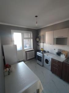 una cocina con lavadora y secadora. en 2-х комнатная квартира en Kyzylorda
