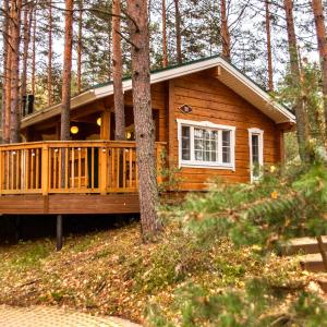 a log cabin in the woods with a porch at Sea Home Resort in Ozerki