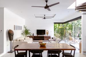 sala de estar con mesa de madera y sillas en Villa Plumeria - Walk to Bingin Beach, en Uluwatu